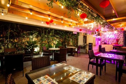 a restaurant with tables and chairs and potted plants at Waikiki Beachside Hostel in Honolulu
