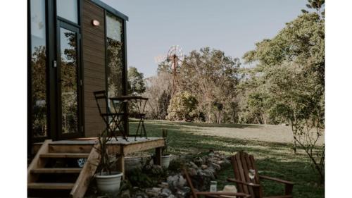 a screened in porch with two chairs and a house at Nomad Nation by Tiny Away in Mount Perry