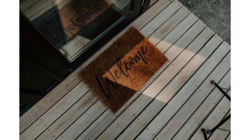 a door mat with the word happy on it sitting on a wooden floor at Nomad Nation by Tiny Away in Mount Perry