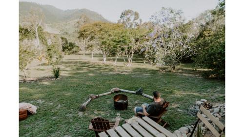 a man sitting on a bench in a yard at Nomad Nation by Tiny Away in Mount Perry