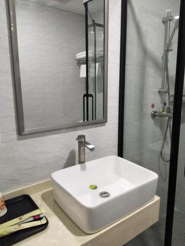 a bathroom with a white sink and a mirror at Ying Feng Yuan Hotel in Guangzhou