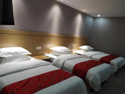 a group of three beds in a hotel room at Ying Feng Yuan Hotel in Guangzhou