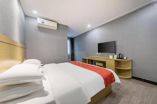 a hotel room with a bed and a television at Ying Feng Yuan Hotel in Guangzhou