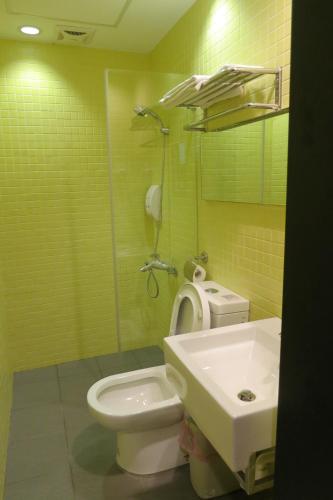 a bathroom with a toilet and a sink at 茶源旅店-潭暉魚池館 in Yuchi