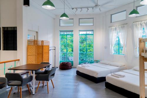 a bedroom with two beds and a table and chairs at Aru corner 6B1BR Tanjung aru town kota kinabalu in Kota Kinabalu