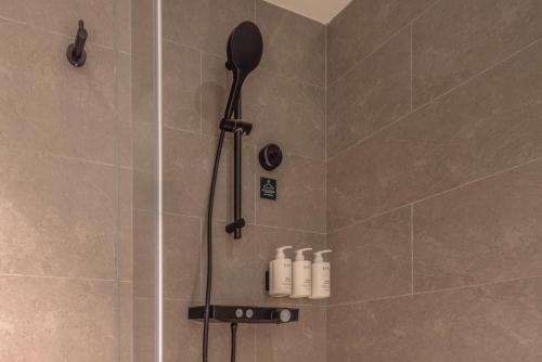 a shower with a black shower head in a bathroom at Atour Hotel Hangzhou Xiaoshan Airport Airport Town in Hangzhou