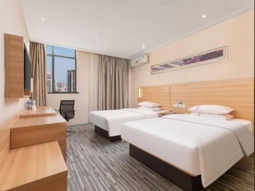 a hotel room with two beds and a desk at City Comfort Inn Huangshi Daye Tongluowan Business Street in Huangshi