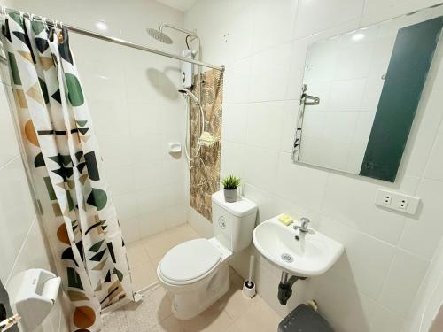a white bathroom with a toilet and a sink at Lyric and Melody Collection in Santa Catalina