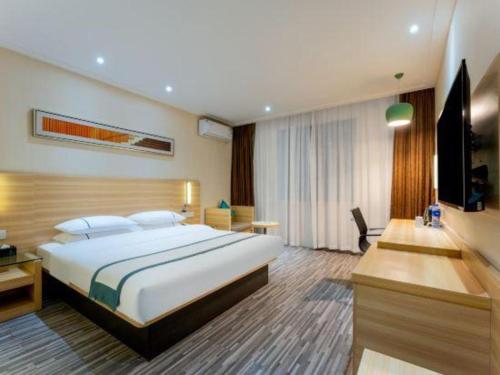 a bedroom with a large bed and a television at City Comfort Inn Suizhou Lieshan Avenue in Suizhou