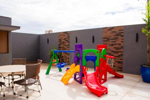 a patio with a playground with a table and chairs at Crystal Place in Goiânia