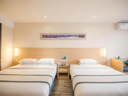 a row of three beds in a hospital room at City Comfort Inn Yichang Dongshan Three Gorges University Shuiyuecheng in Yichang