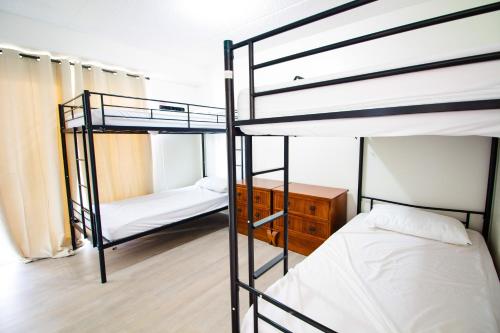 a room with three bunk beds and a desk at Waikiki Beachside Hostel in Honolulu