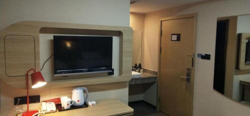 a hotel room with a flat screen tv on the wall at Thank Inn Plus Hotel Xinjiang Urumqi Tianshan District Bingtuan Erzhong in Ürümqi