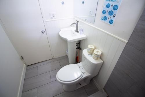 a small bathroom with a toilet and a sink at Waikiki Beachside Hostel in Honolulu