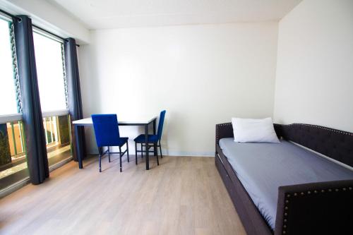 a room with a bed and a table and chairs at Waikiki Beachside Hostel in Honolulu