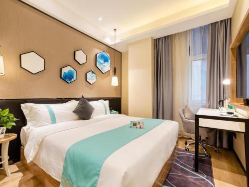 een hotelkamer met een bed en een bureau bij Xana Lite Tianjin Ninghe Trade Development Zone in Ninghe