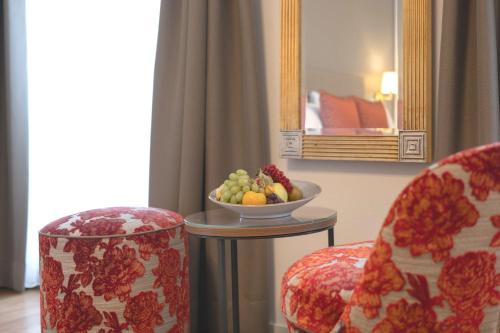 a room with two chairs and a bowl of fruit on a table at Hotel Des Alpes in Luzern