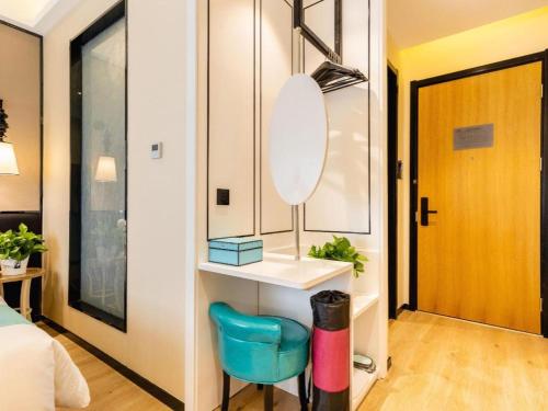 een slaapkamer met een spiegel en een blauwe stoel bij Xana Lite Tianjin Ninghe Trade Development Zone in Ninghe