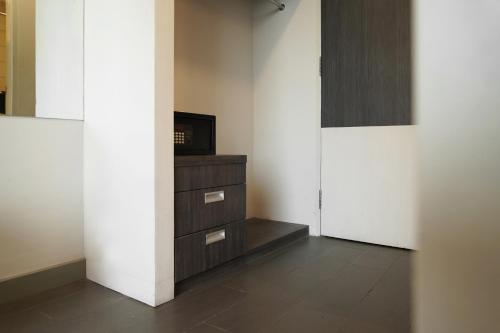 a room with a tv on a dresser and a door at Dreamtel Jakarta in Jakarta