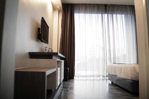 a hotel room with a bed and a large window at Dreamtel Jakarta in Jakarta