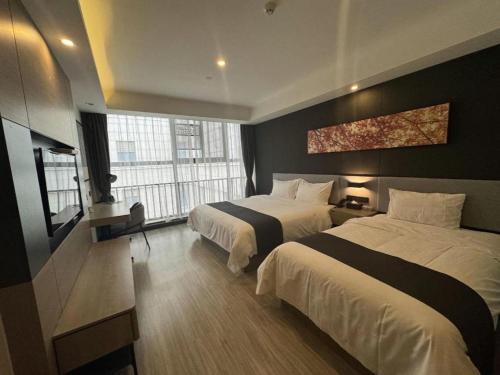 a hotel room with two beds and a window at GreenTree Alliance Hotel Suzhou Dangshan Lihua Square in Dangshan