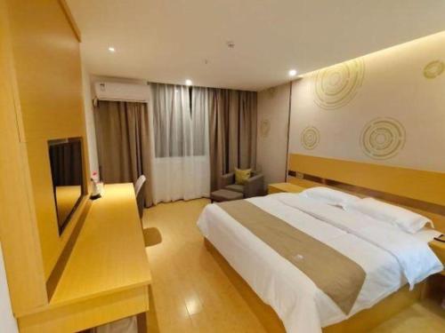 a bedroom with a large bed and a television at GreenTree Inn Linhai Jiangnan Avenue Express in Linhai