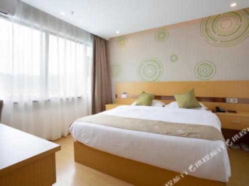 a bedroom with a large bed and a large window at GreenTree Inn Linhai Jiangnan Avenue Express in Linhai