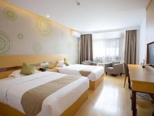 a hotel room with two beds and a desk at GreenTree Inn Linhai Jiangnan Avenue Express in Linhai