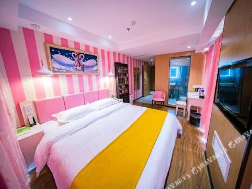 a bedroom with a large bed and a television at Echarm Hotel Hefei West Qilitang Metro Station in Hefei