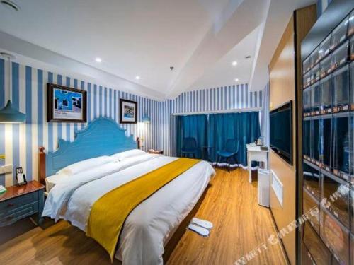 a bedroom with a large bed and blue and white stripes at Echarm Hotel Hefei West Qilitang Metro Station in Hefei