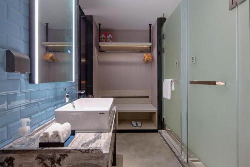 a bathroom with a sink and a shower at Echarm Hotel Nanning Wuming in Wuming