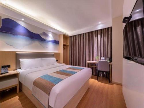 a hotel room with a large bed and a table at VX Hotel Xiamen Siming District Xiamen University Huandao Road in Xiamen