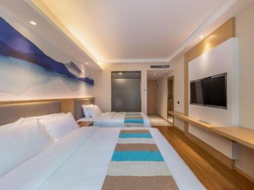 a hotel room with a large bed and a flat screen tv at VX Hotel Xiamen Siming District Xiamen University Huandao Road in Xiamen