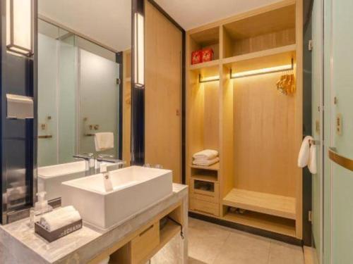 a bathroom with a white sink and a mirror at Echarm Hotel Hefei West Qilitang Metro Station in Hefei