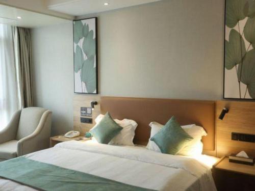 a hotel room with a bed and a chair at GreenTree Inn Anqing Yingbin Dong Road High-Speed Railway Station in Anqing
