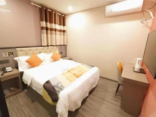 a hotel room with a bed and a desk at Shell Hotel Shanghai Jinshan Wanda Plaza in Nanhui