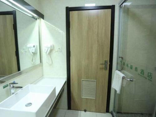 a bathroom with a sink and a shower with a mirror at GreenTree Inn Anqing Yingbin Dong Road High-Speed Railway Station in Anqing