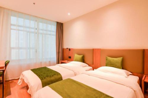 a hotel room with three beds and a window at GreenTree Inn Express Lanzhou West Passenger Station Lanzhou Center in Lanzhou