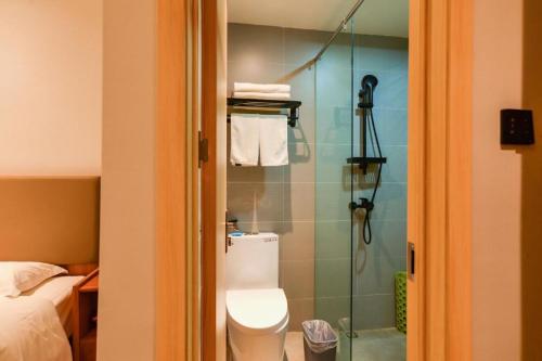 a bathroom with a toilet and a glass shower at GreenTree Inn Express Lanzhou West Passenger Station Lanzhou Center in Lanzhou