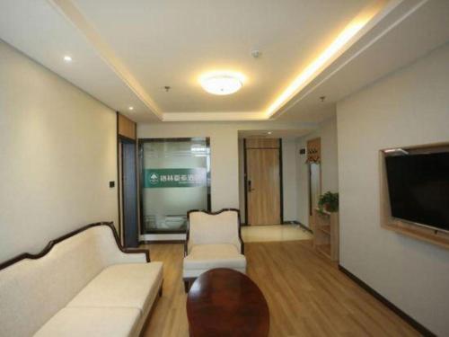 a living room with a couch and a flat screen tv at GreenTree Inn Anqing Yingbin Dong Road High-Speed Railway Station in Anqing