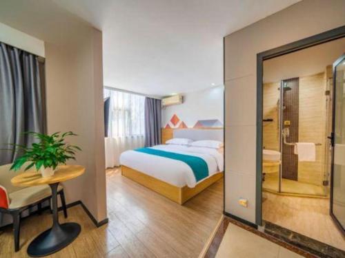 a hotel room with a bed and a glass door at Borrman Hotel Guilin Elephant Hill Park Li Lake in Guilin