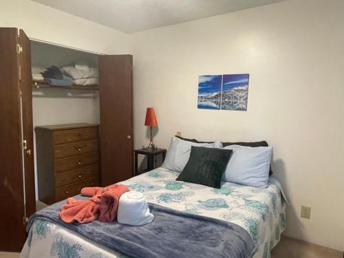a bedroom with a bed with an orange robe on it at Captain's Quarters - Reduced Price Tours! in Mendenhaven