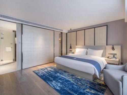 a bedroom with a large bed and a couch at Echarm Hotel Nanning the MixC Dongmeng Business District in Nanning