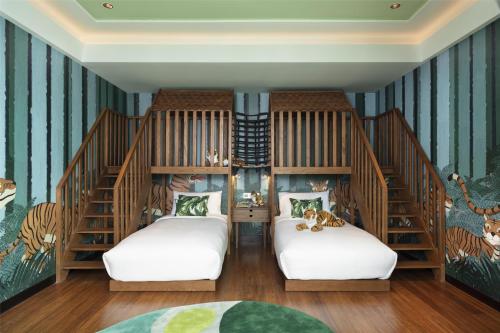two beds in a room with striped walls at Siam Kempinski Hotel Bangkok in Bangkok
