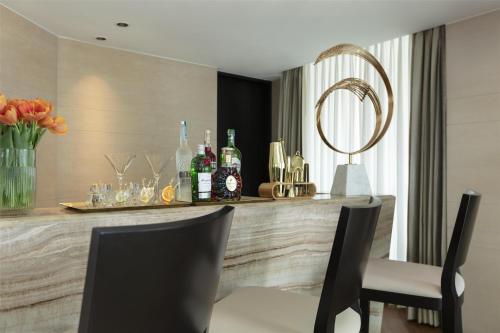 a bar in a room with bottles and chairs at Siam Kempinski Hotel Bangkok in Bangkok