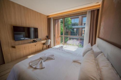 a hotel room with a bed with a large window at Riverton Hotel in Samut Songkhram