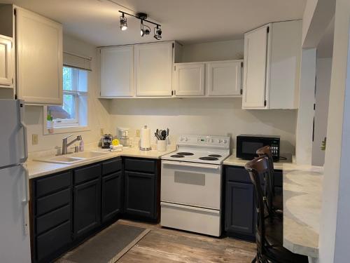 ガードウッドにあるChalet Gallery - Enjoy Two Units with this Chalet in the Heart of Alyeska - Walk almost anywhere!のキッチン(白いキャビネット、白いコンロ付)