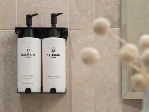two bottles of balm on a wall in a bathroom at Sofitel Sydney Wentworth in Sydney