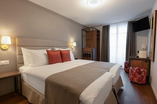 a hotel room with a large bed and a window at Hotel Des Alpes in Luzern