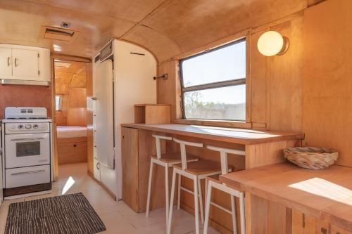 a kitchen in a tiny house with a table and a window at Cozy Retreat Amidst Boulders in Yucca Valley